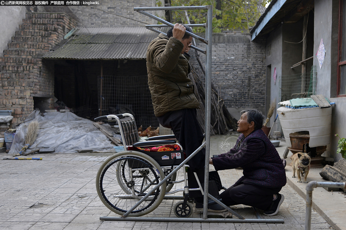 八旬老母孤身照顾残儿25年     老妈妈帮助保安练习臂力，害怕久而久之的不活动导致肌肉萎缩，丧失手臂功能。