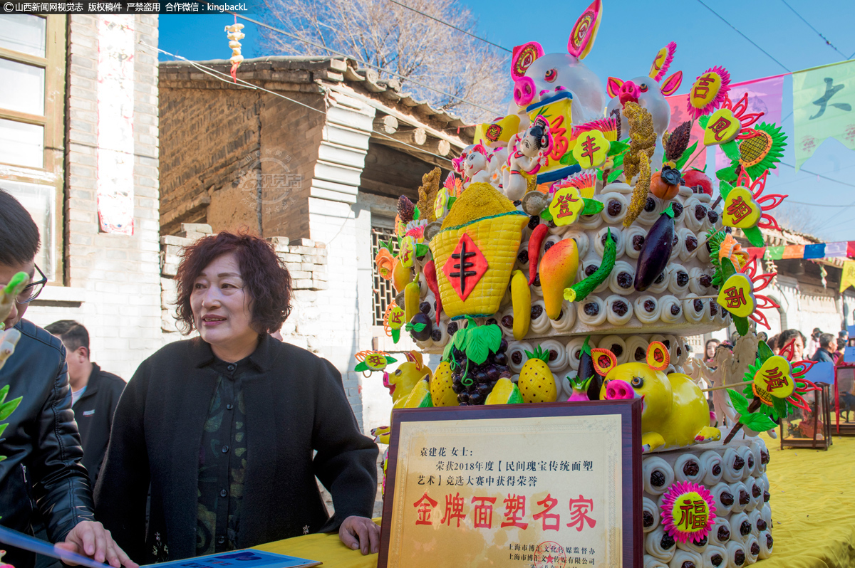      袁建华在展台前与参观者进行交流。