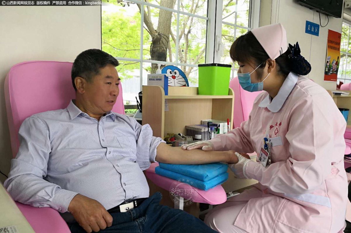      在献血屋的征询区，医护人员正在向郅向东询问献血的相关事宜。