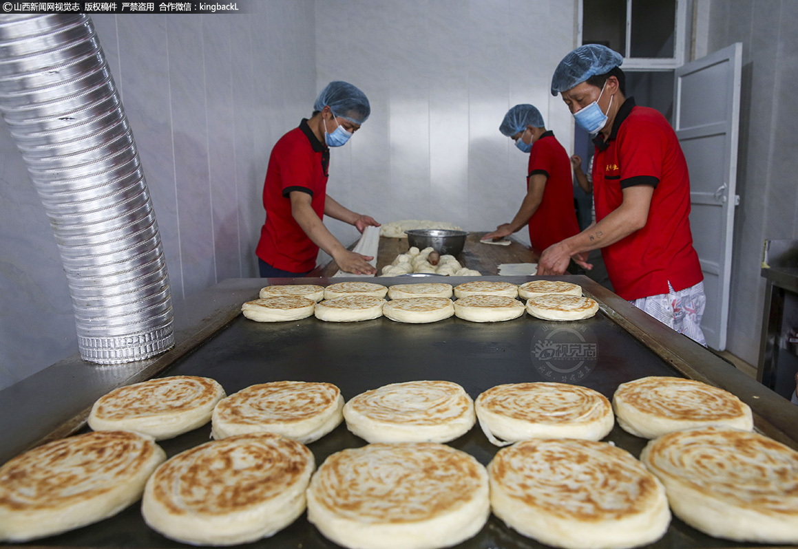      走进饼子店，张师傅和他的员工正在焕然一新的燃气烤饼子的作坊里忙着加工饼子。
