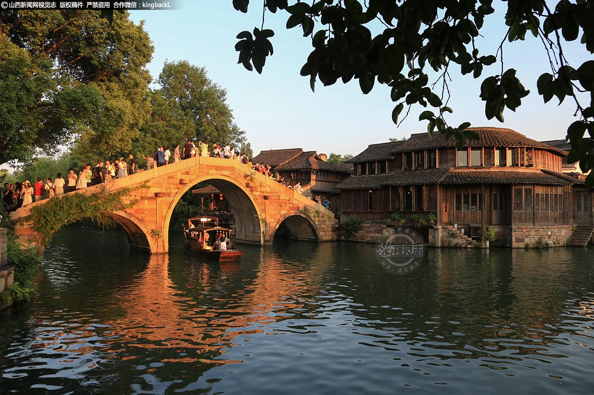     旅游旺季，即便知名水乡的高票价远超故宫，依然没有阻挡国人去打卡的热情。本应是闲适婉约的水乡，一下子熙熙攘攘起来，活生生变成了现实版的清明上河图。行走其间，一不留神，不是被人流挤进旅行团的队伍，就是自己看景误入了他人的镜头。