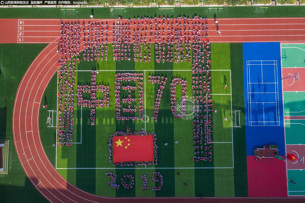      9月30日，忻州市保德县第二小学500余名师生在操场上拼出大型图案，庆祝新中国成立70周年。（摄影师：杨宇龙）