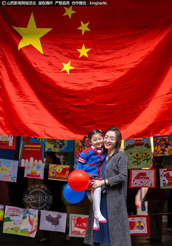      9月30日下午，吕梁市泰化幼儿园举行“爱我中华 喜迎国庆”主题亲子活动。图为小朋友和妈妈与国旗合影。（山西新闻网特约摄影师：冯帅 ）