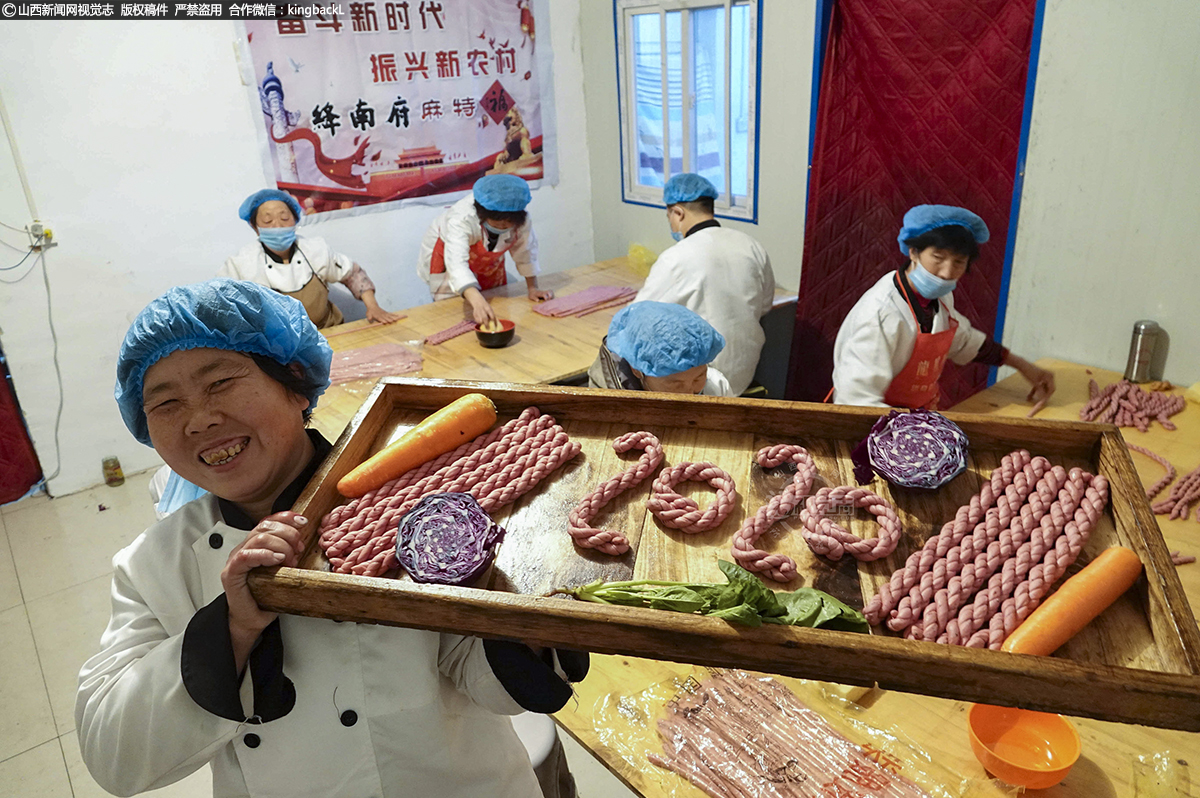      麻特是晋南农村人对麻花的特称，绛州麻特在历史发展的长河中形成了自己独到的特色，它比不上麻花的酥无筋骨，但却皮脆劲三分。随着2020年新年临近，在新绛县文侯村绛南府麻特作坊，女工们搓、炸麻特一派繁忙。图中，“绛南府”麻特作坊坊主行新枝信心百倍展示2020年创业梦想。（■本期摄影：高新生）