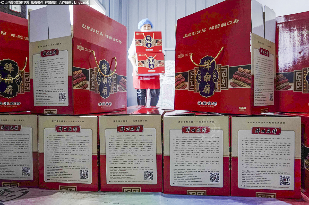      女工将生产的麻特搬运装箱，行新枝的“绛南府”品牌，坚守良心底线，继承传统技艺，改进工艺设施，让绛州传统麻特再一次风采重现。