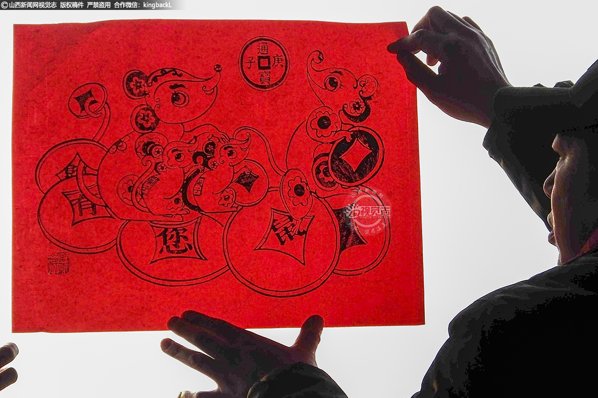      杨淑云在张贴生肖鼠系列木版年画。绛州木版年画品种繁多，手法齐全，雕版技术精湛，线条细腻，年画内容所能体现的历史脉络清晰，艺术价值极高。