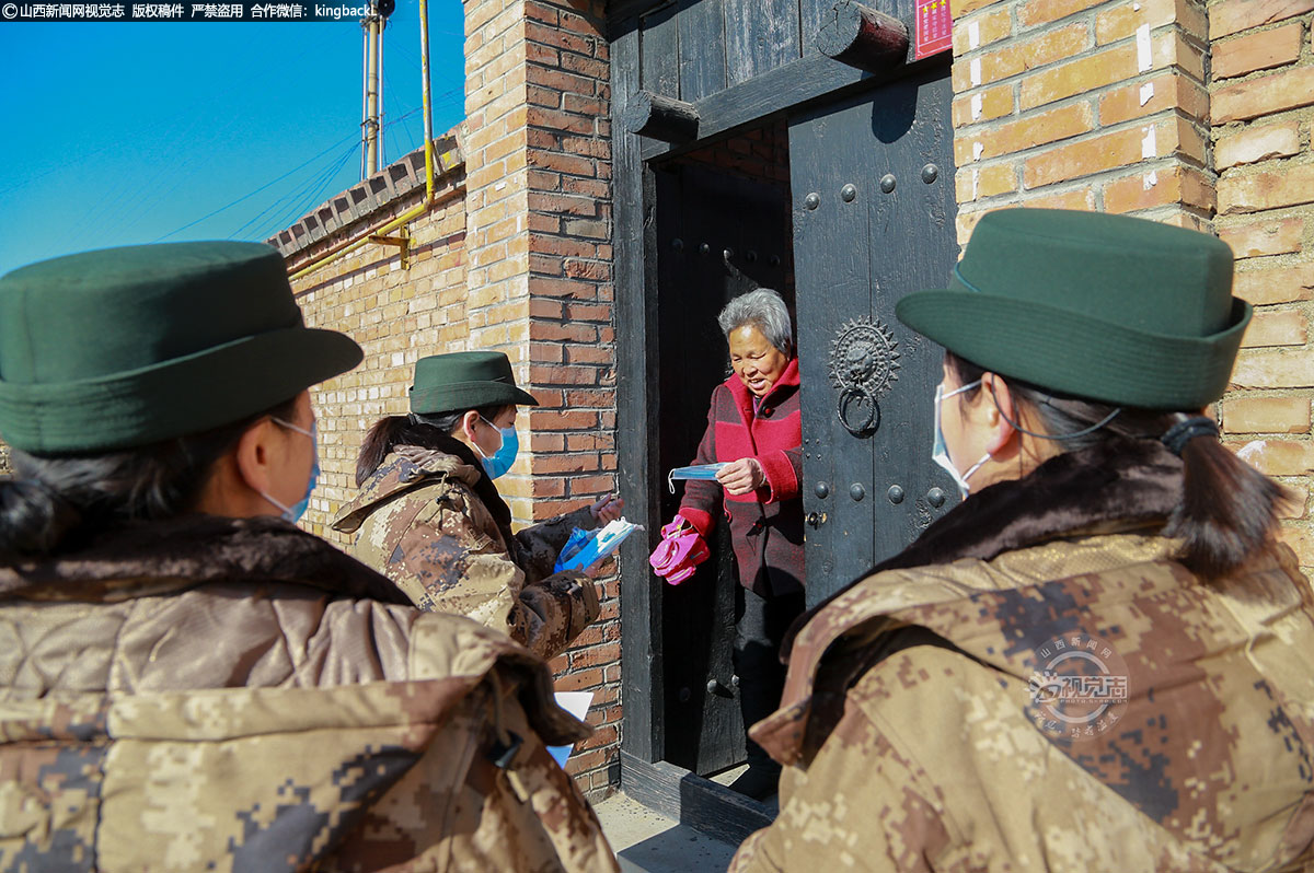      “大妈，送您一口罩，现在疫情严重，没事别出门啊......”在盂县路家村镇张家垴村，一支身穿军装的队伍走在疫情防控的第一线，她们就是张家垴女子民兵班。（■山西新闻网特约摄影师：赵五明）