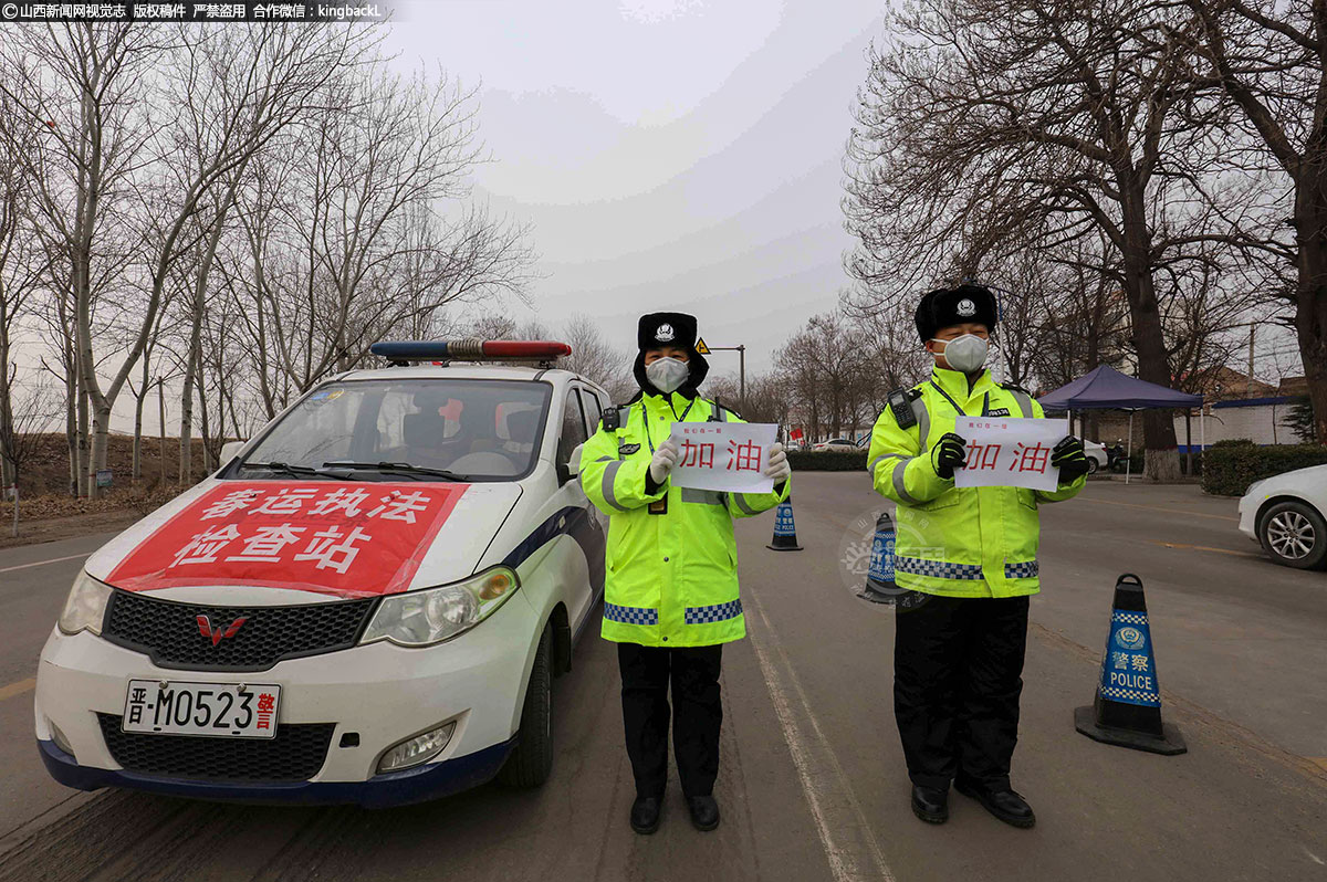      在新型冠状病毒疫情发生以来，河津市交警大队迅速启动一级勤务，全体民警、辅警取消春节假期及休假，全员投入到防疫阻击战工作中，在一线防疫工作中，协警人员面对疫情，舍小家顾大家、义无反顾的投身到防疫一线，用实际行动书写着美丽“逆行”。图为女协警米江红与战友一起为坚守在防疫一线的战友加油。（■山西新闻网特约摄影师：李泓晓）