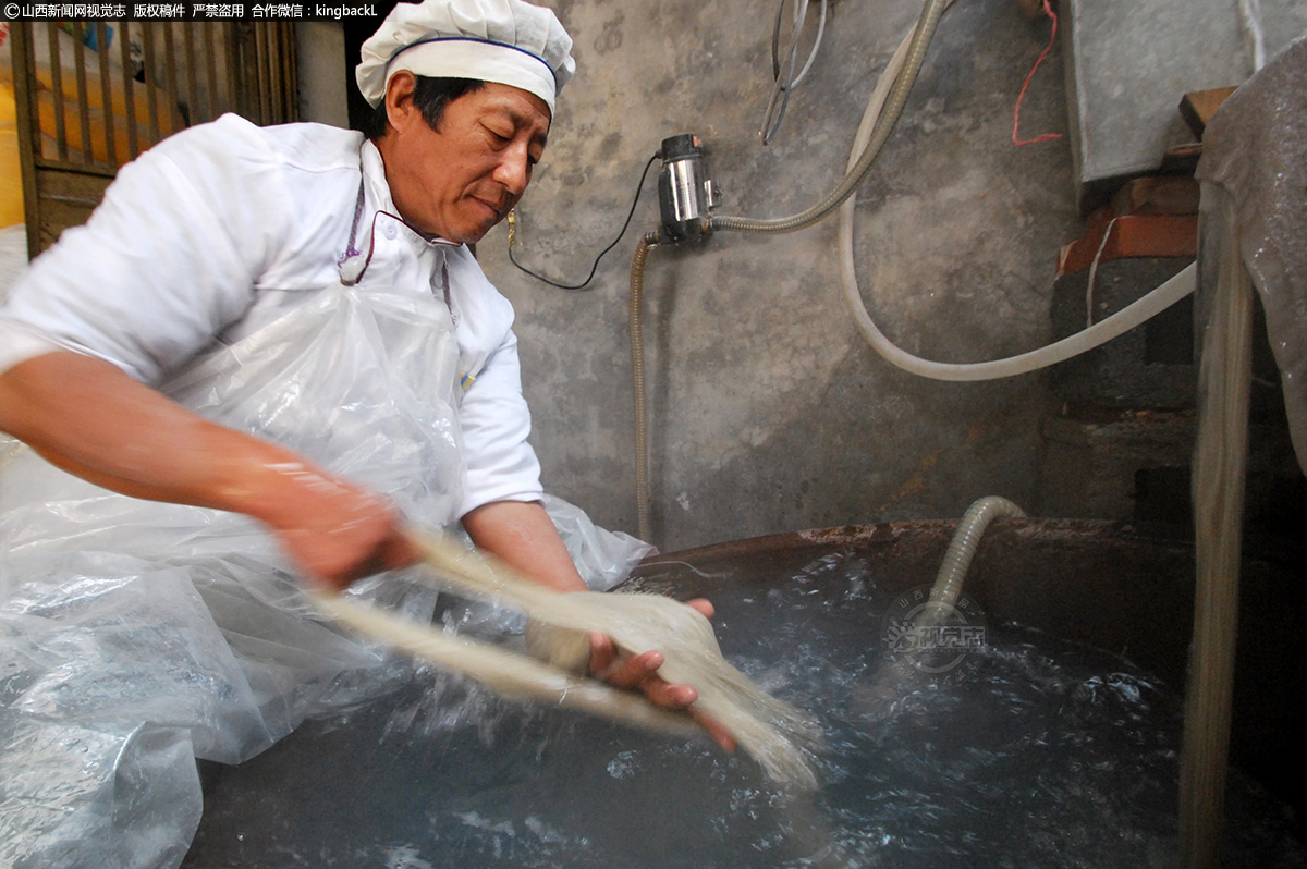      在热水锅旁放着一个冷水缸，粉条成型后从热水锅用长筷夹至冷水缸，粉条冷却些捞出，接着需要将这些粉条整齐的盘在竹竿上，以便之后晾晒。柴师傅称这道工序叫做盘粉条。