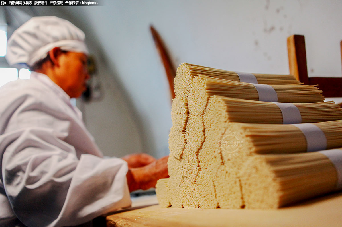      经过充足阳光和微风的共同作用，等挂面脱干了水分，每根挂面细如发丝，布有微孔。夫妻二人将挂面下架，上案板，切割成约六十公分左右的长度，然后称斤打捆，此时挂面完工。