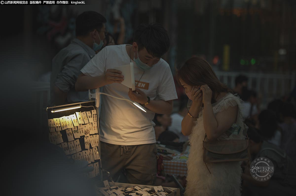      一位摊主举着镜子说：“真的很漂亮，这款特别适合你。”一番试戴后，女孩买了一对耳饰。都说人间烟火气，最抚凡人心，这样的夜晚，让人如此的放松。