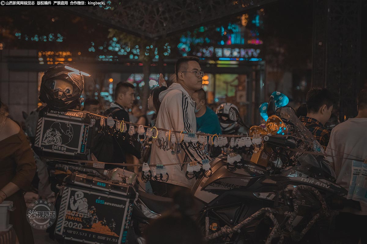      在夜市的一个角落，一位骑手在自己的“爱车”上摆放销售一些小饰品。相较于收入，他可能更享受这种夜市的惬意。年轻人在繁忙的生活中，高强度的工作，长时间的学习，一天下来，只有夜晚才属于自己。