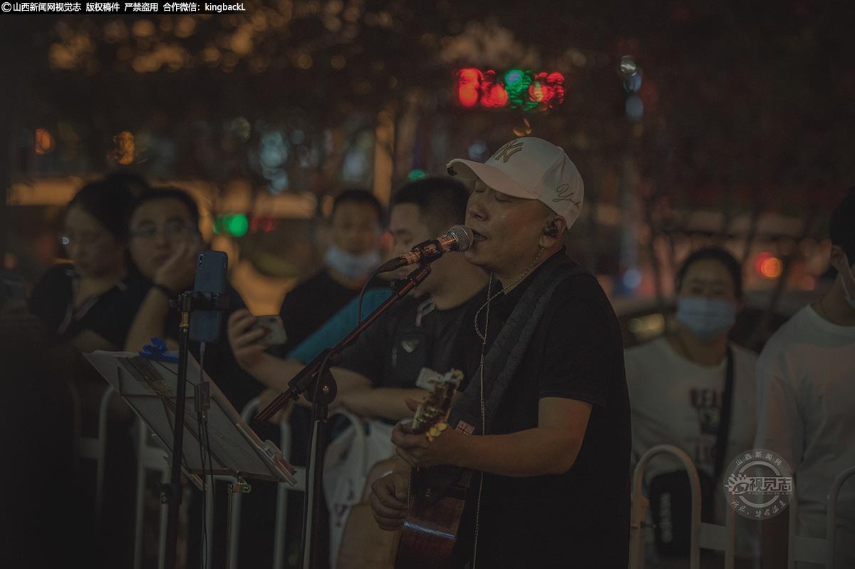      与动感的摇滚乐队不同，一位民谣歌手抱着吉他弹奏着舒缓的旋律，用清澈的嗓音为市民倾情献唱。不论在夜市的哪种风格吟唱或者表演，他们充盈的是市民的夜生活，点缀的是太原夜经济。