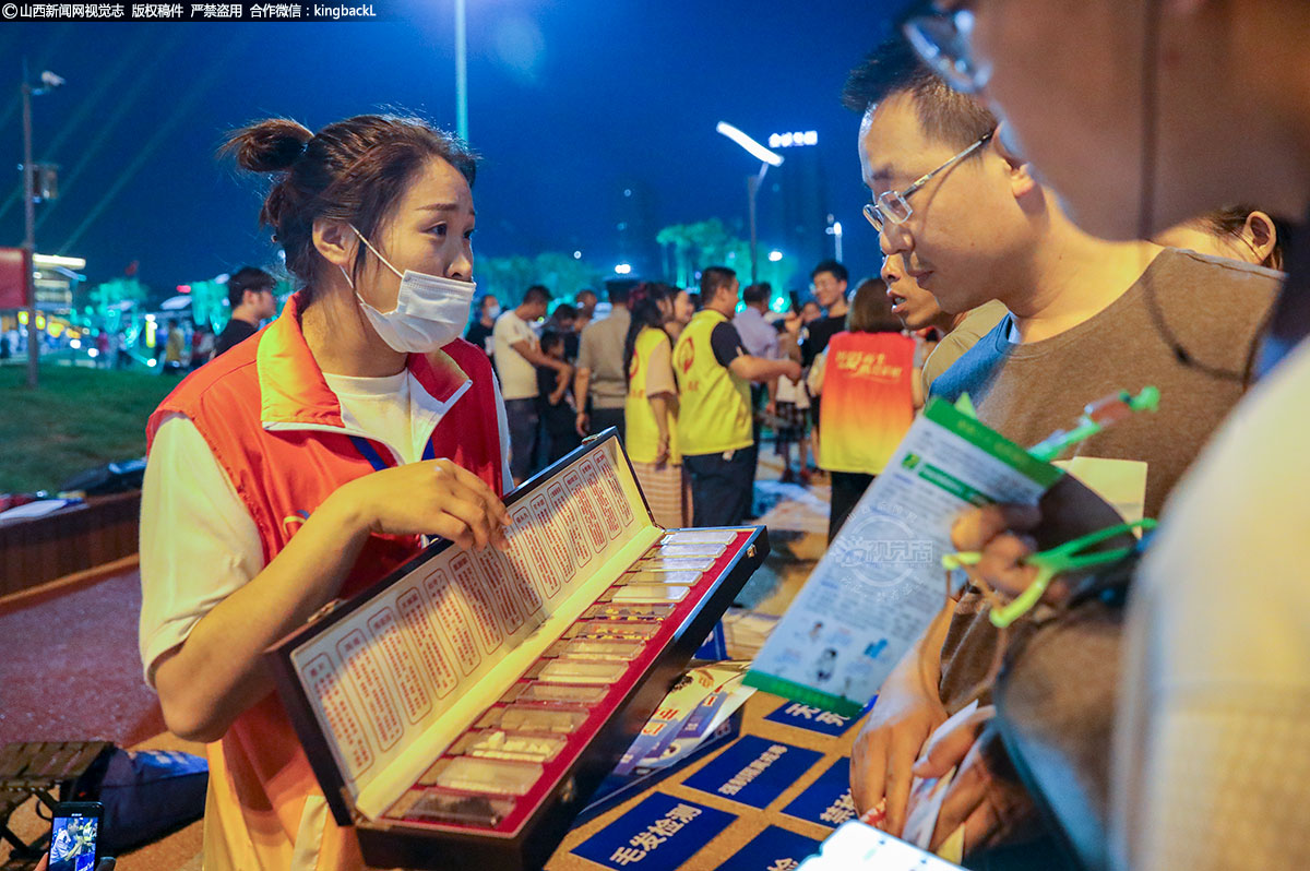      路过群众认真仔细查看纸条上的禁毒法律知识问题，三五成群，互相讨论，积极参加到禁毒有奖知识竞答活动中来。