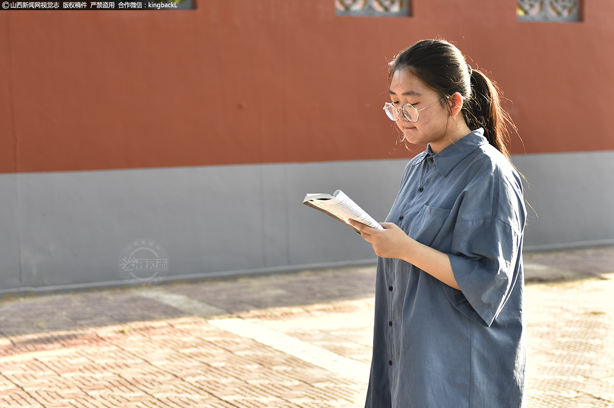      山西省河津市第二初中考点外，学生在参加考试的路上仍在复习。（山西新闻网特约摄影师：吴云生）