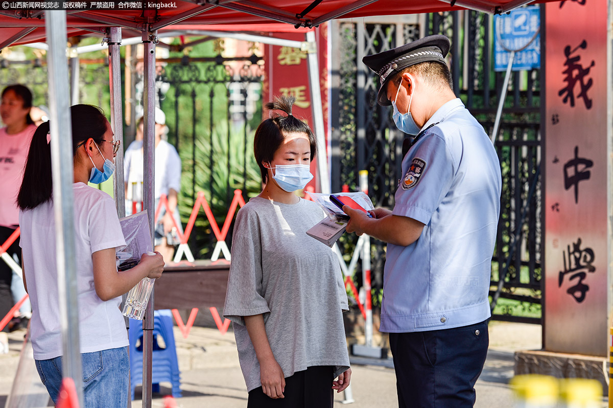      山西省孝义市一中考点，工作人员用检录仪核实考生身份。（山西新闻网特约摄影师：孙燕）