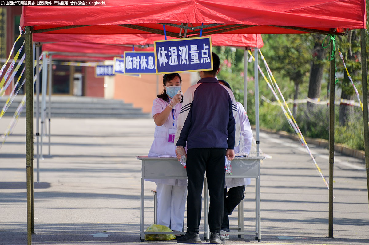      山西省神池二中考点，医务人员为考生测量体温。（山西新闻网特约摄影师：肖巍）