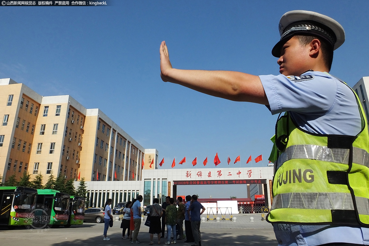      山西省运城市新绛县第二中学考点，交警正在考点外指挥交通。（摄影师：高新生）