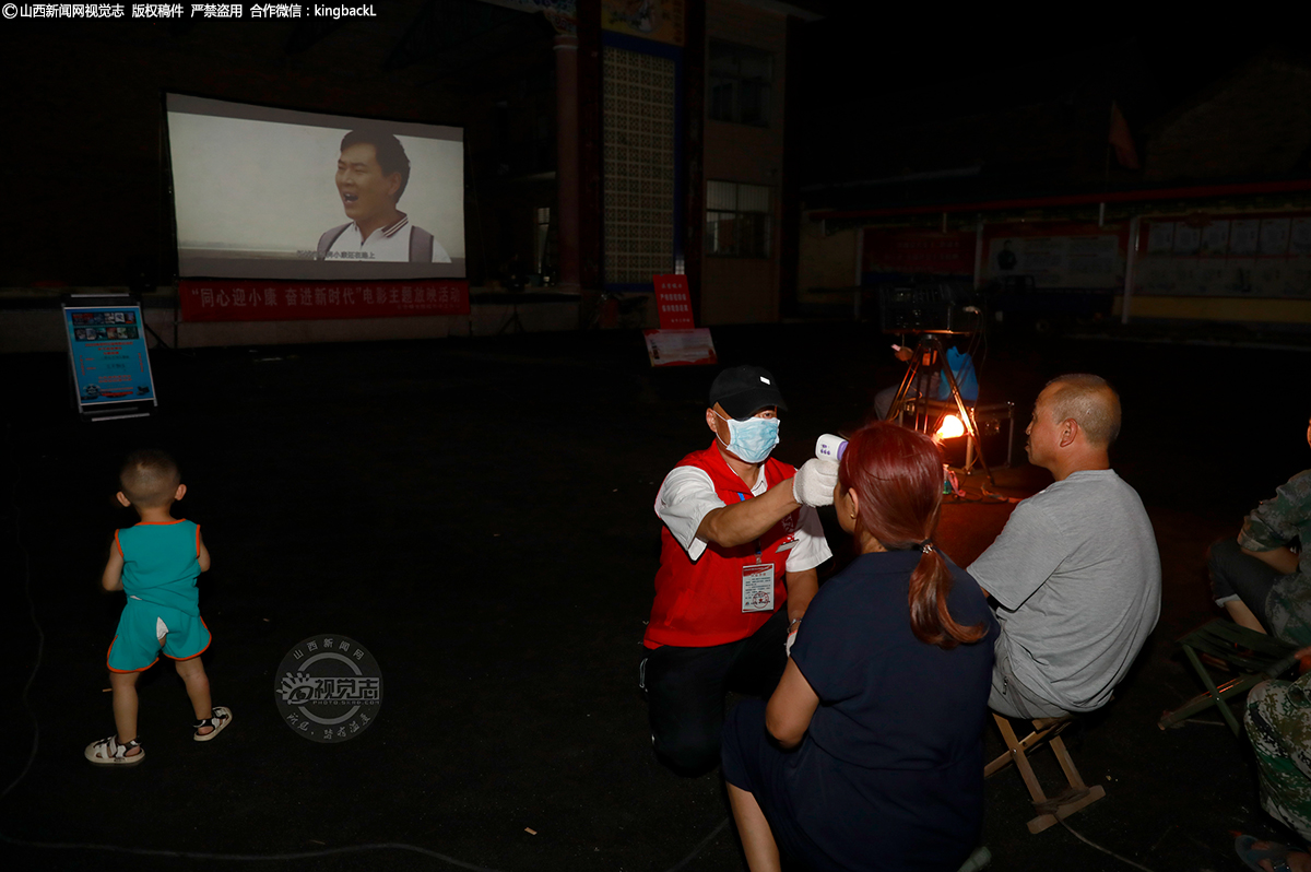      放映员在放映前为观众测量体温。放映过程中，放映员全程戴口罩播放电影，确保防疫、放映“两不误”。