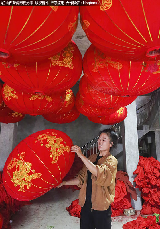      灯笼产业园区内正“马力”十足，为全国各地客户赶制红灯笼，喜迎国庆佳节。图为马长江的媳妇，正在展示她家的灯笼，她家做灯笼已经有三十年了。