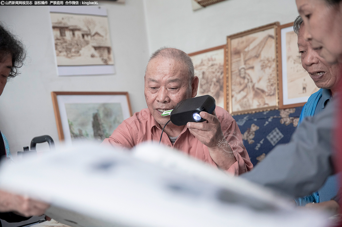      焦老师与时俱进，可以熟练的使用现代科技产品。他正给老年大学的同学讲解用投影仪器辅助绘画的技能。