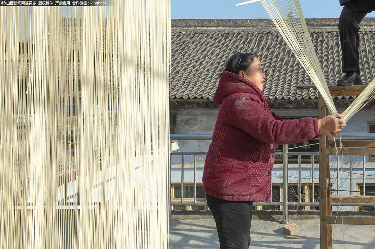     一把鲁因挂面，清香绵软，朴实无华，从切断的截面看，每根面中间都有一个小孔，做出的挂面是“空心”的，这也正是它的魅力所在。图为周福合的妻子，正在帮忙。
