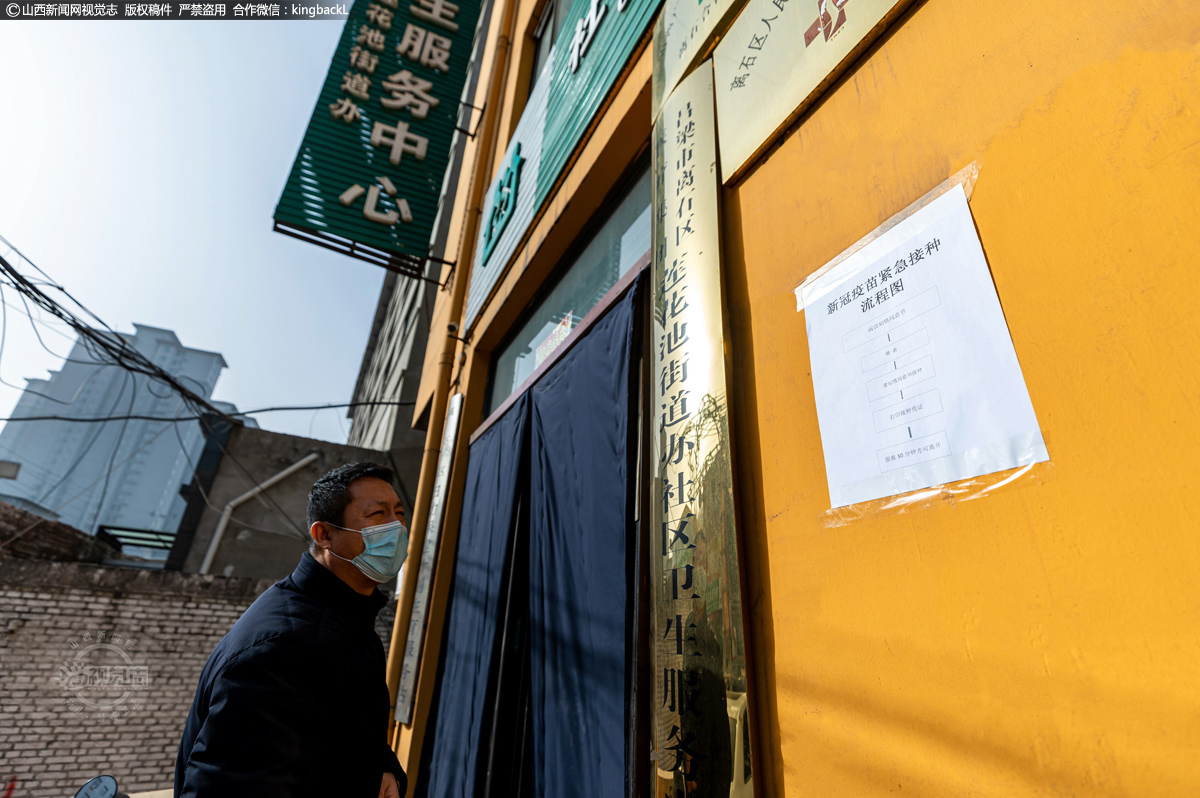      在社区卫生服务中心接种点入口处，张贴了新冠疫苗紧急接种流程图。一位来接种疫苗的公交车司机在进入社区时认真阅读接种流程。