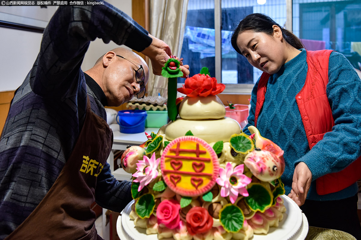      年近五旬的孝义市面塑非遗传承人陈建功，是孝义市美术馆长期特聘的面塑老师。每年临近春节，陈建功就会天天做面塑、蒸花馍。面团在他的指尖翻飞变化，新颖的花样，鲜艳的色彩，受到众多老百姓的喜爱，而传统的手艺也成为当地不可多得的非遗文化技艺。（■山西新闻网特约摄影师：孙燕）