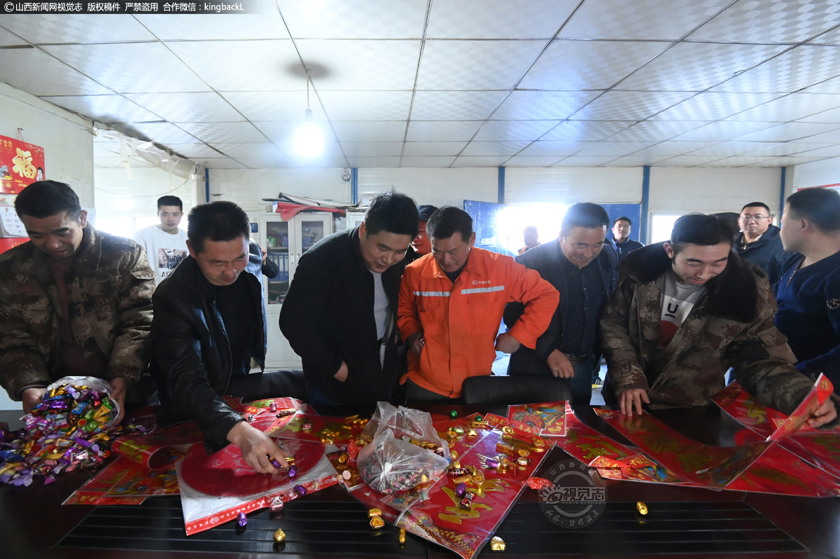      糖果、对联、福字……浓浓的过年气氛，留岗务工人员正在挑选承建单位送来的“新春礼包”。