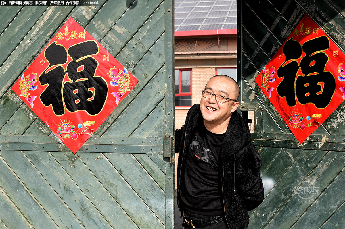      2月11日，大年三十，寿阳县南燕竹镇韩庄村，村民望着自己贴的对联，喜上眉梢。（山西新闻网特约摄影师：原海春）