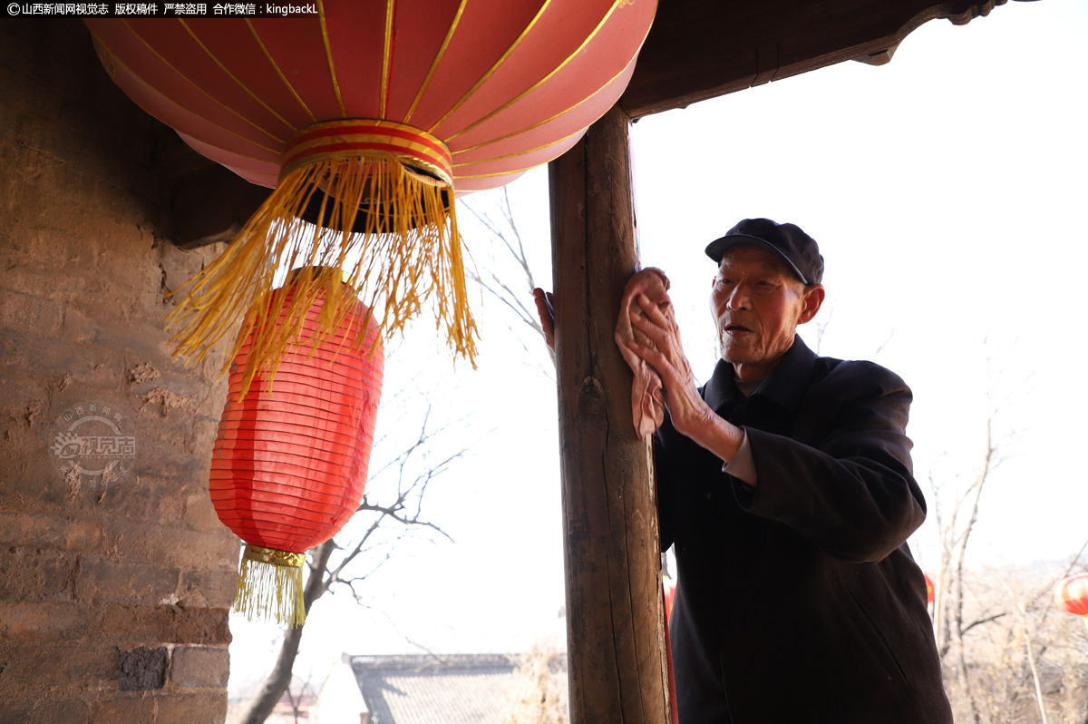      2月11日，大年三十上午，在长治市上党区西岭村，89岁的陈老伯正在贴对联。（山西新闻网特约摄影师：鲍晓峰）