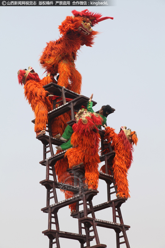      领狮人在塔顶表演“金鸡独立”、“三角倒立”、“辫腿”等高难动作，头顶在8寸宽的板凳中心，双足朝天，一手执毛笔，一手捧纸板书写，表演“空中倒福”绝活。四只狮子分别围在凳塔的四个方向，做着各种动作，没有丝毫的畏惧心理。