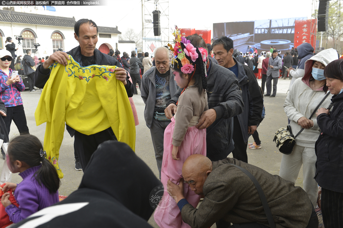      第三步，便开始给小演员穿表演服装。服装一定要和道具保持协调一致，上面表演的孩子和下面扛背棍的大人组成一组戏。