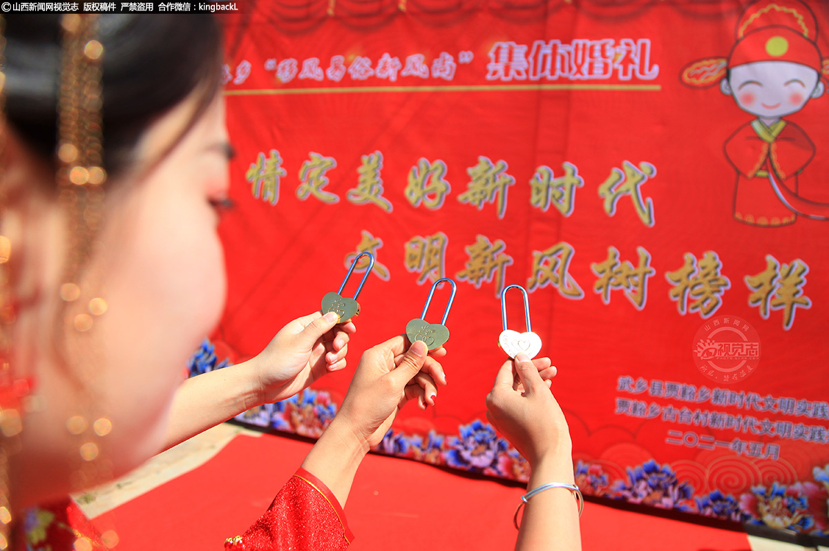      三名新娘将心愿写到连心锁上。新人悬挂连心锁的传统由来已久，把象征着自己的爱情锁锁在桥上，寓意可以锁住永恒的爱。 