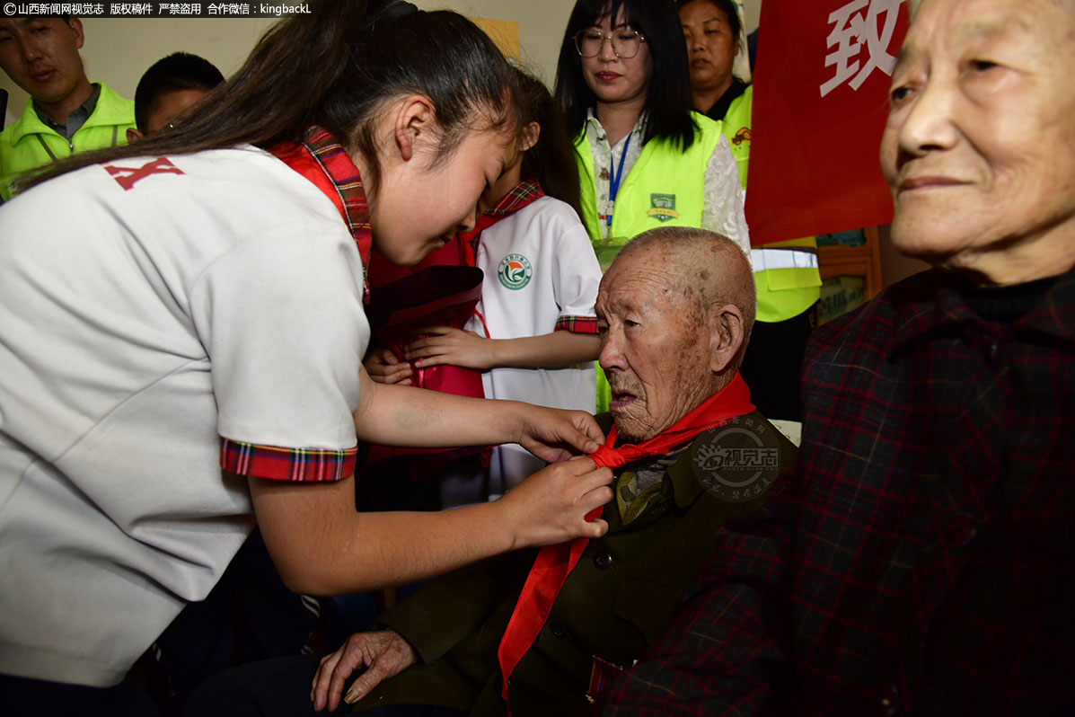      开栅小学的少先队员也来到家里，为他亲手带上红领巾，致以崇高的队礼，为老人献上鲜花，还给年迈的爷爷系上了红领巾，并把自己带来的朗诵节目表演给爷爷。