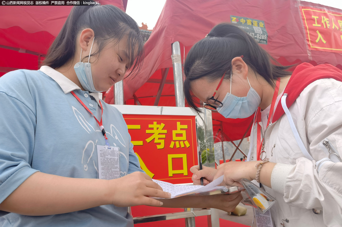      6月7日，在河曲中学考场，进考场前考生在完善14天体温登记表。（山西新闻网特约摄影师：聂新光）