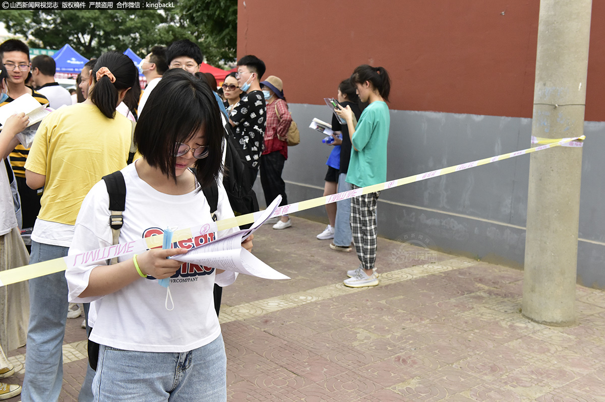      6月7日，河津第二中学考场外，学生正翻看复习资料。（山西新闻网特约摄影师：吴云生）