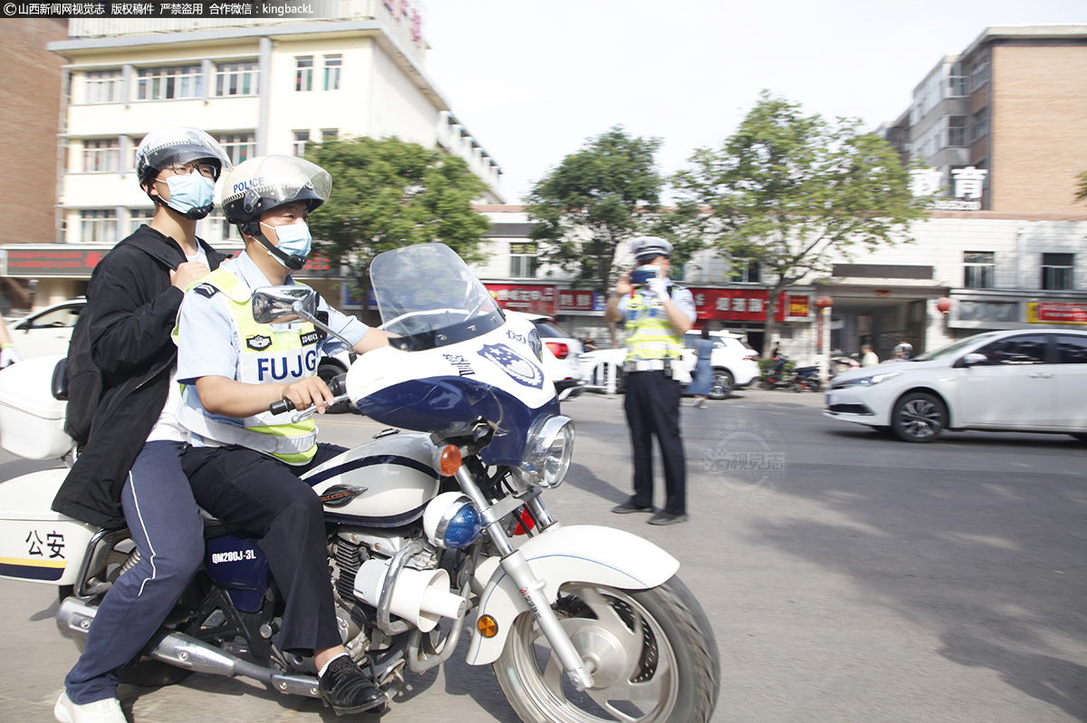      6月7日，早上八点，长治六中考点外，长治市公安局交警支队二大队民警带一名忘记拿准考证的考生取回准考证。（山西新闻网特约摄影师：张向军） 