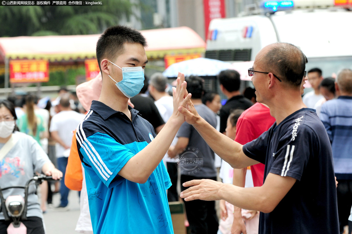      6月7日，万荣中学考点，一名考生和陪考的爸爸相互击掌。（摄影师：张怀心）