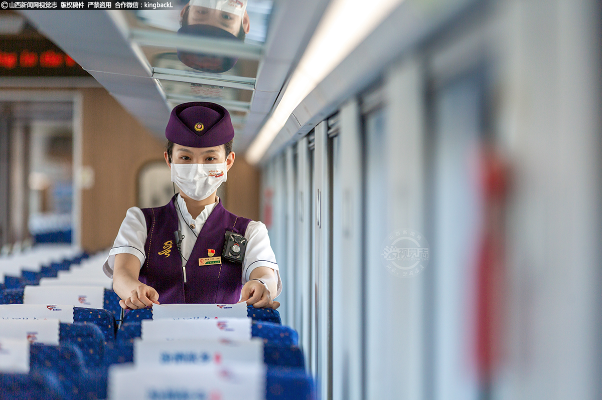     一名乘务员正在整理座位枕巾。“复兴号”动车组相较于普通列车，该车型乘坐空间更宽敞，每排座席均设有插座和USB充电口，可调节座椅、无障碍设施、全覆盖WIFI等贴心设计让出行更加舒适。