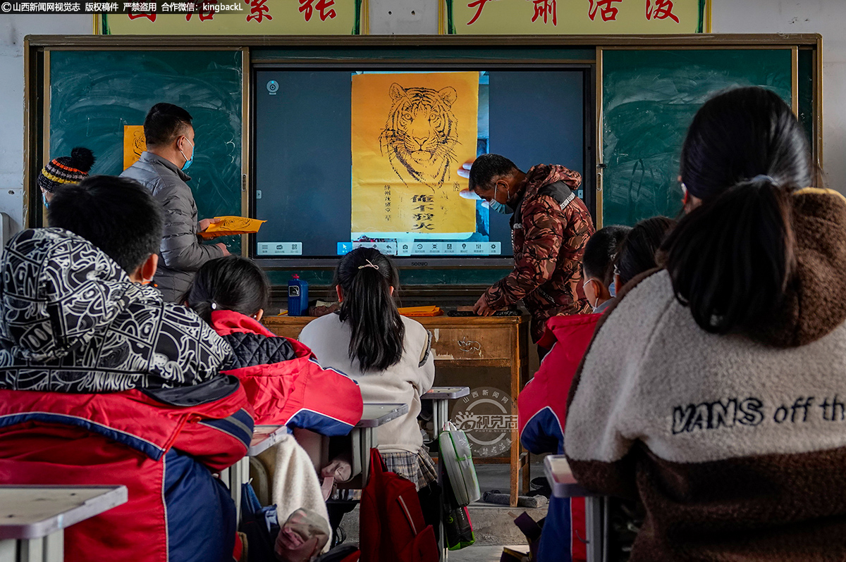      ‎1‎月‎7‎日，随着农历虎年临近，运城市新绛县泽掌镇光村小学，绛州木版年画社工艺师们携带新创作的虎年生肖虎绛州木版年画走进校园，同小学生一起印制虎年生肖虎系列绛州木版年画。（■本期摄影：高新生）