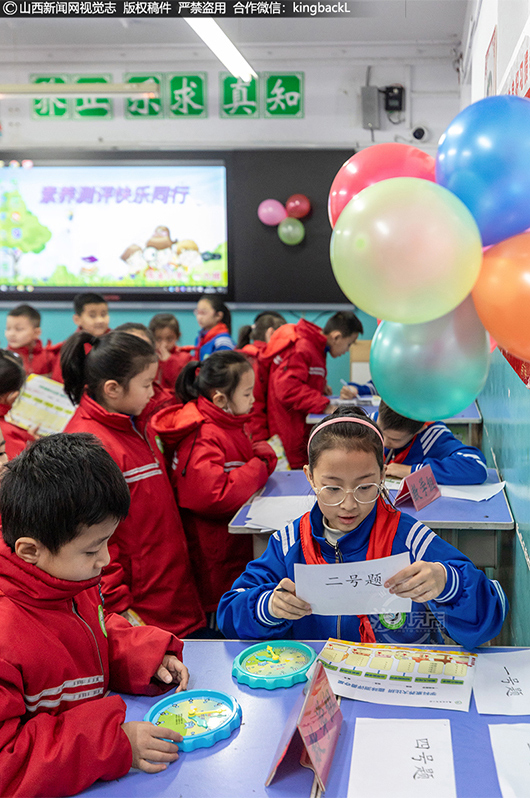      在各个考场，学生们五人一组有序地在“关卡”前排队抽取答题号。