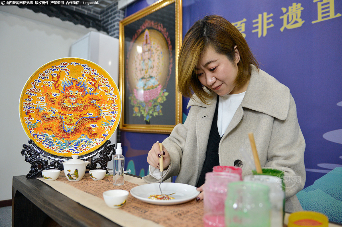      庄秋燕，山西太原人，金丝珐琅画技艺的代表性传承人。她非美术专业科班出身，但生在艺术世家，从外曾祖母开始，到奶奶、爸爸，皆从事与美术相关的工作，34岁的她依旧沉浸在艺术环境里。（■山西新闻网特约摄影师：闻进）