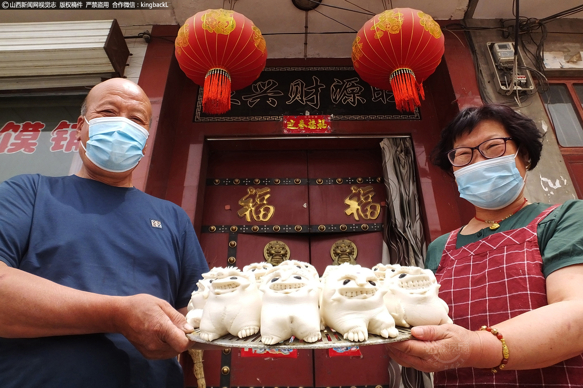      在山西省运城市新绛县泽掌村，村民高光焕（左）和妻子卫栓女在花馍店前拍视频网上销售端午老虎馍。