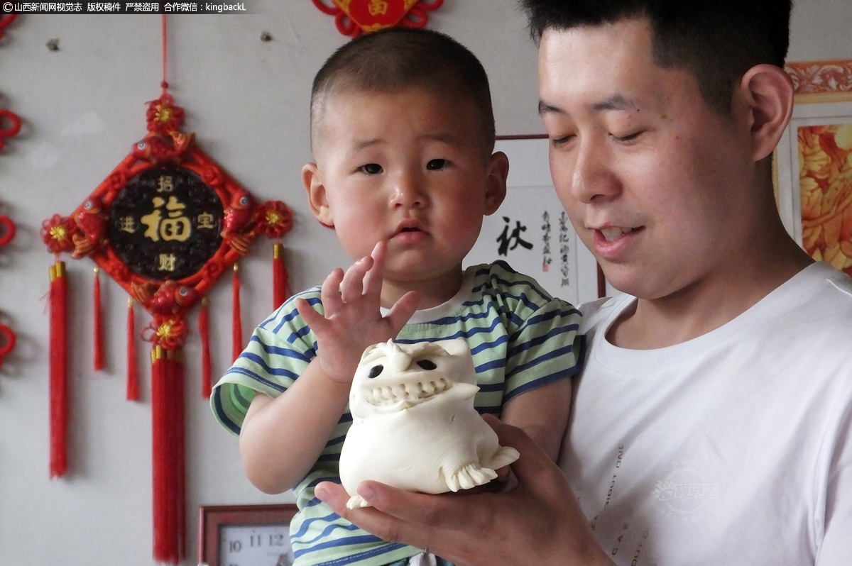      来自邻村小聂村的村民正在给孩子挑选端午老虎花馍。端午老虎花馍不仅成年人喜欢，也深得小朋友的喜爱。