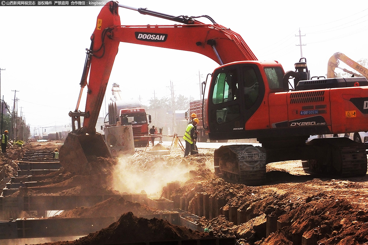      在重点项目工程山西运城市新绛县108国道防洪建设工地，工人和大型机械在高温下加紧施工。
