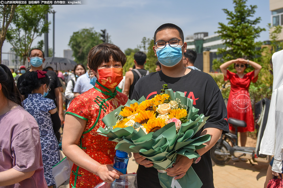      6月7日，太原市第五十二中学校考点，高考第一场语文考试结束后，一位身着旗袍的家长为考生送上鲜花。（山西新闻网记者：苏航）