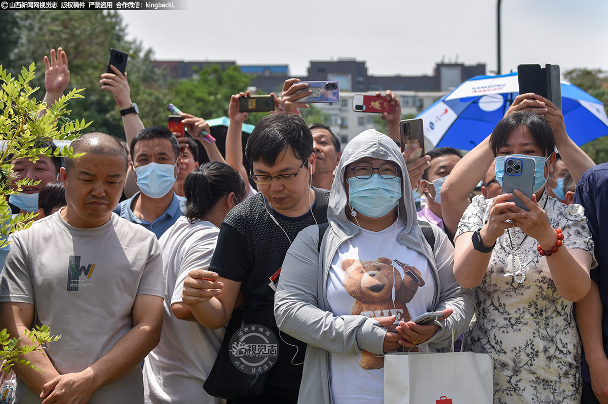      6月7日，太原市第五十二中学校考点，高考第一场语文考试结束后，家长拍摄考生走出考场的画面。（山西新闻网记者：苏航）