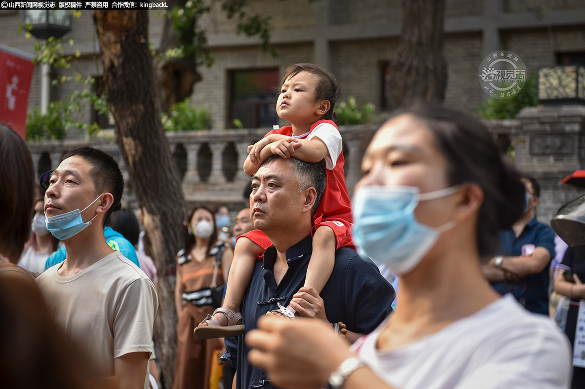      6月7日下午，在太原市第二外国语学校考点，第二场数学考试结束后，一位家长带着肩上“骑高马”的孩子等待考生出场。（山西新闻网记者：苏航）