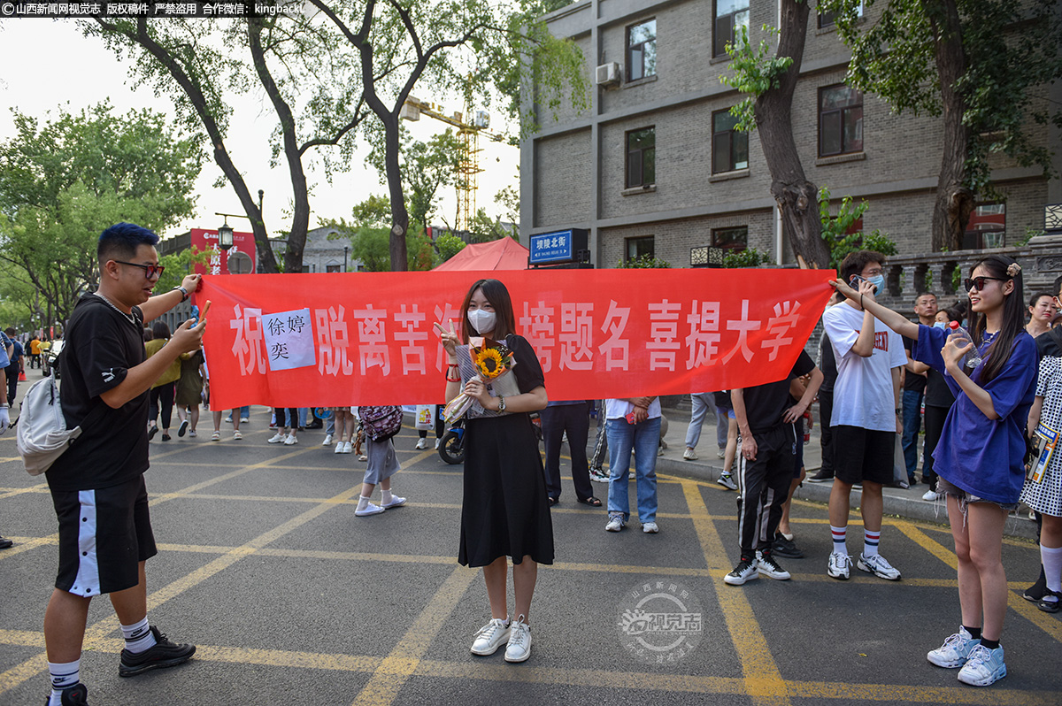      6月7日下午，在太原市第二外国语学校考点，第二场数学考试结束后，好友为考生拉起横幅助威、摆好姿势拍照，纪念这特殊的一天。（山西新闻网记者：苏航）